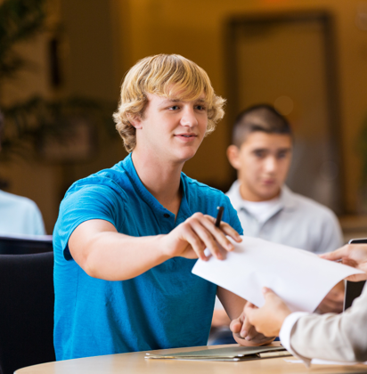 Student die een papier afgeeft 