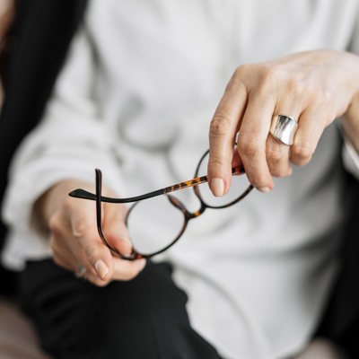 Handen van een vrouw die een bril vasthoudt